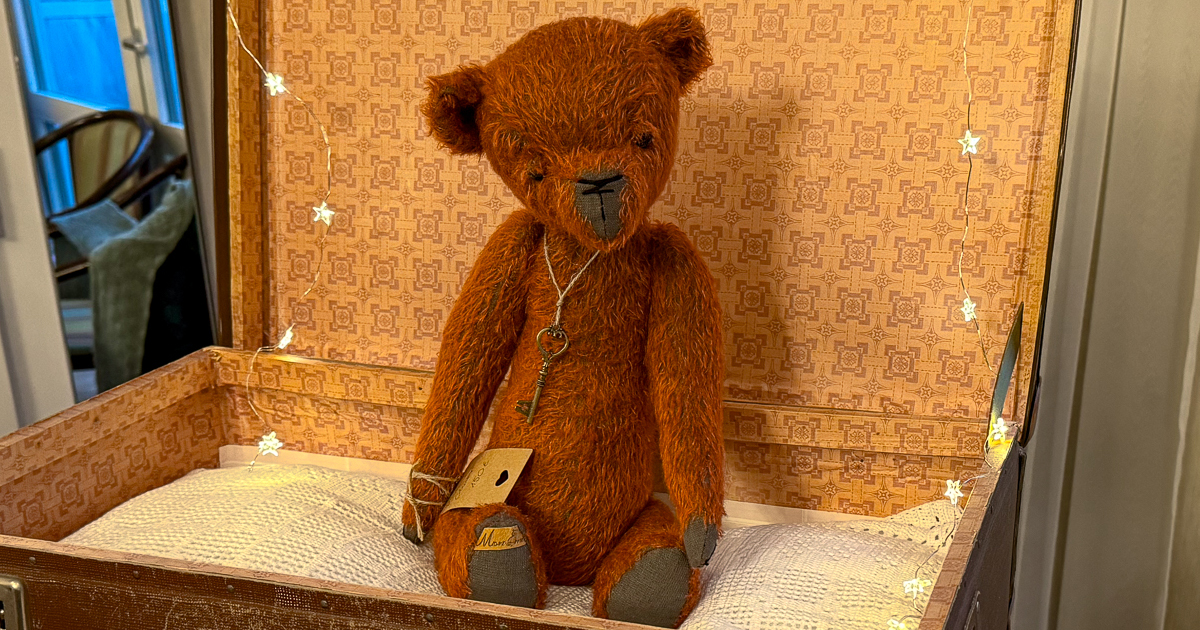 Ein Teddybär sitzt in einem alten Koffer