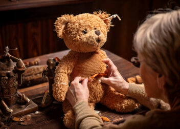 Eine Restauratorin arbeitet an einem alten Teddybär